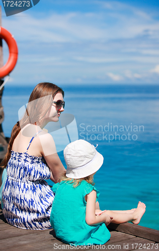 Image of Mother and daughter sitting on wooden dock