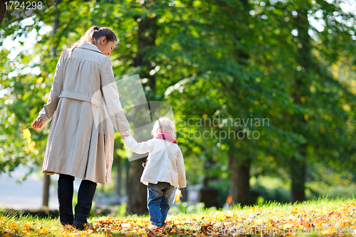 Image of Mother and daughter walking in park