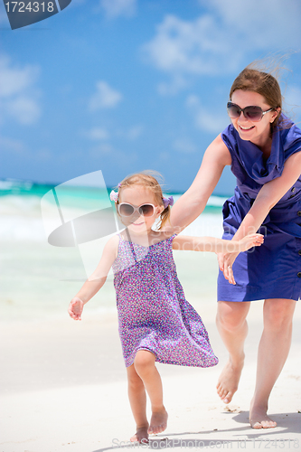 Image of Mother and daughter running at beach