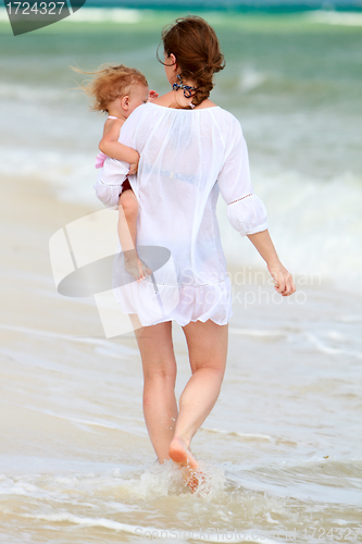 Image of Mother and baby walking along beach