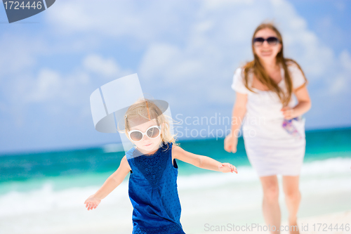 Image of Mother and daughter running at beach