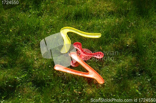 Image of flying boomerang toys lying on grass. Outdoor game 