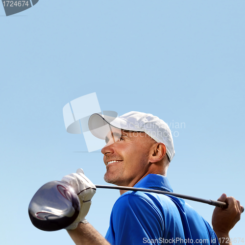 Image of Smiling golfer holding golf club over shoulder 