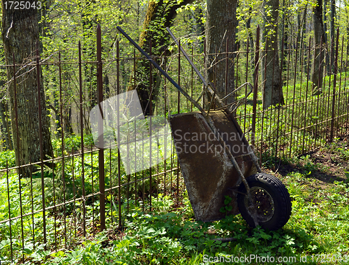 Image of Old rusty garden tool wheelbarrow metal fence 