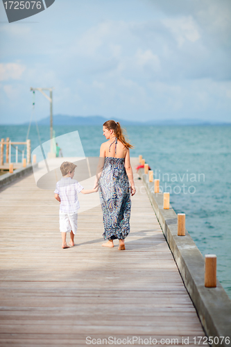 Image of Mother and son walking along jetty