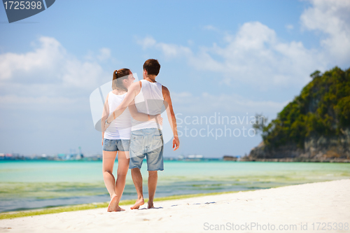 Image of Romantic couple walking along tropical beach