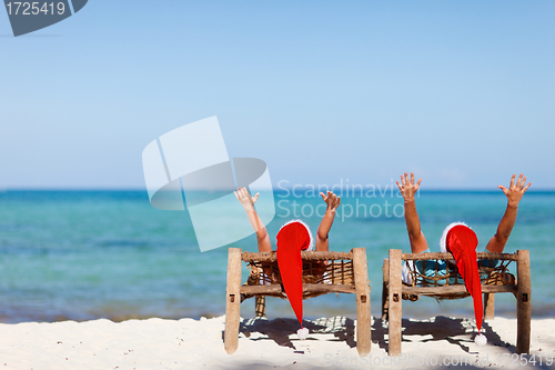 Image of Couple in Santa hats on tropical beach