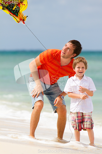 Image of Father and son flying kite together 