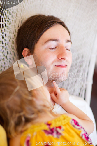 Image of Father and daughter relaxing in hammock