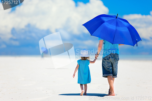 Image of Father and daughter walking at beach