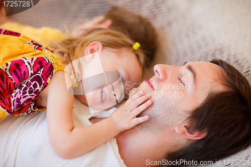 Image of Father and daughter relaxing in hammock