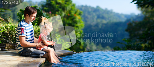 Image of Father and daughter near swimming pool