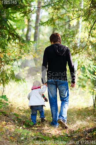 Image of Father and daughter walking in park