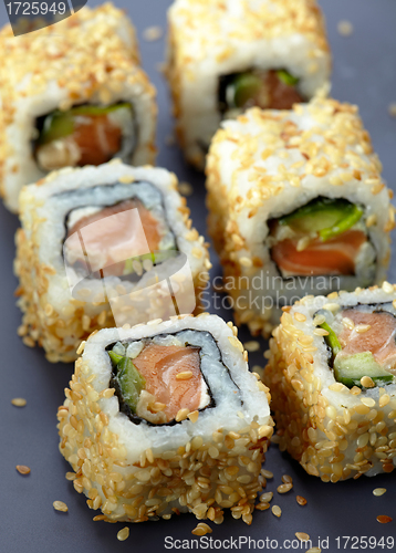Image of sushi with salmon and cucumber with sesame seeds