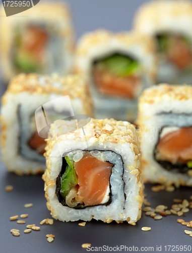 Image of sushi with salmon and cucumber with sesame seeds