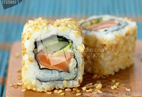 Image of sushi with salmon and cucumber with sesame seeds