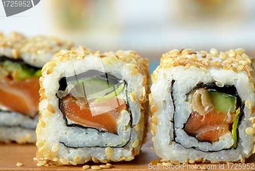 Image of sushi with salmon and cucumber with sesame seeds