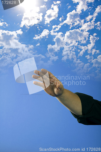 Image of hand over blue sky