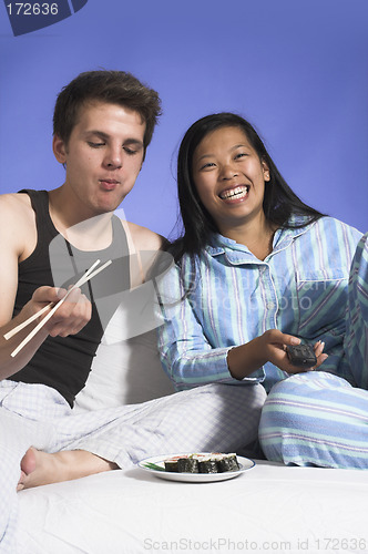 Image of couple watching TV and eating