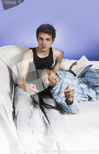 Image of couple on couch pointing finger at camera