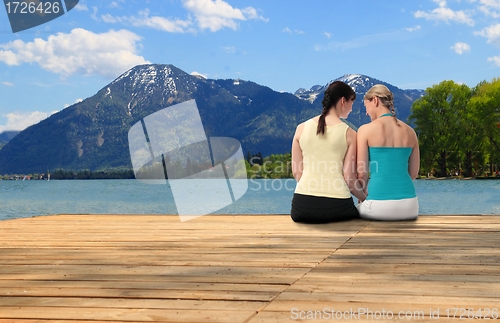 Image of Two young woman chatting at a lake