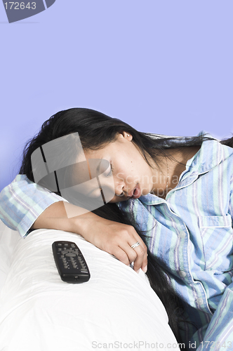 Image of woman sleeping on couch with remote aside