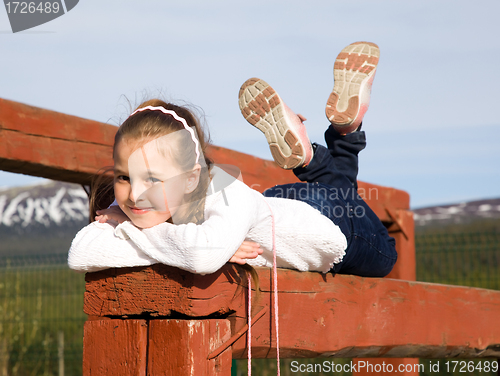 Image of A girl lies on the balance beam and smiling