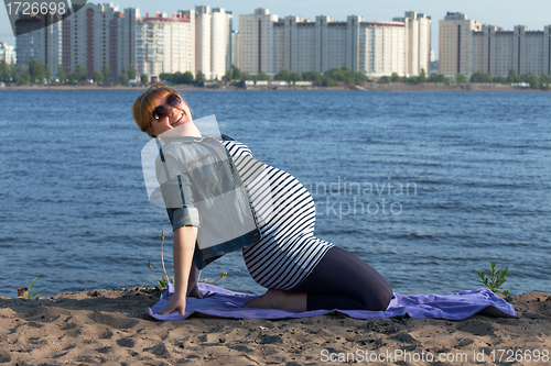 Image of Pregnant woman doing gymnastic exercises