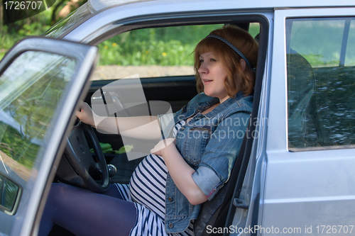 Image of Pregnant woman speaking to her belly in the car