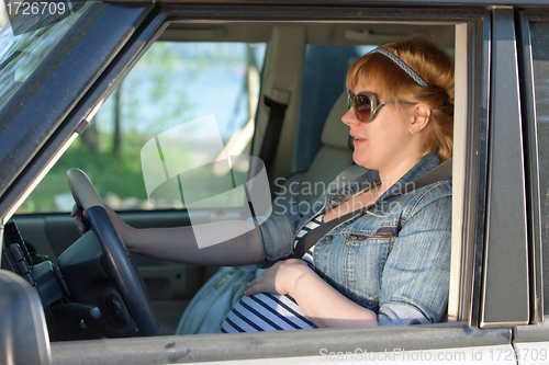 Image of Pregnant woman speaking to her belly in the car