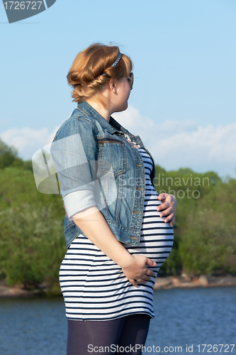 Image of Pregnant woman on the river coast