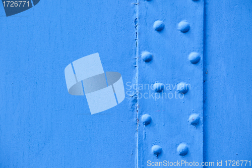 Image of blue metal surface with rivets