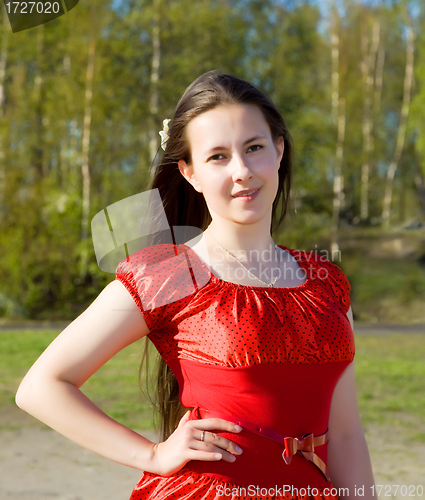Image of portrait of a beautiful girl in a red dress with her hair