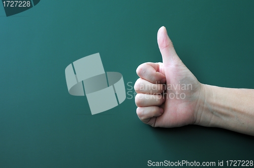 Image of Thumb up on a blackboard background