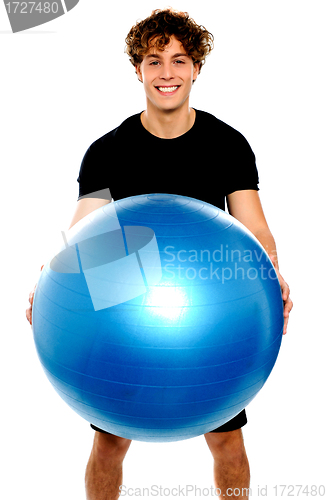 Image of Man in sportswear holding big ball