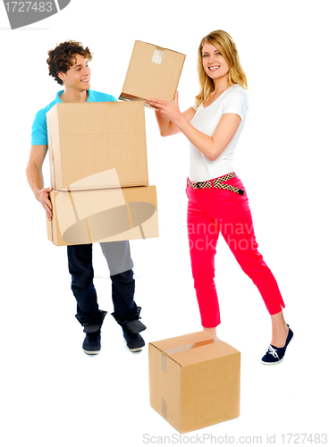 Image of Smiling couple moving cardboard boxes