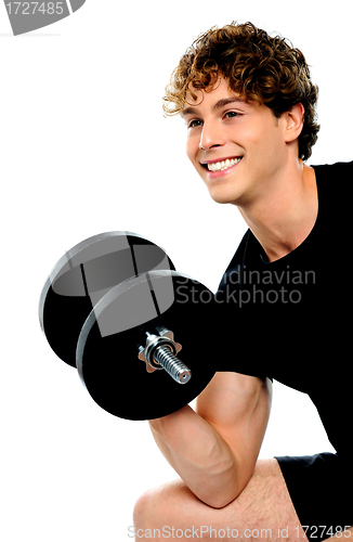 Image of Muscular man in black sportswear with dumbbell