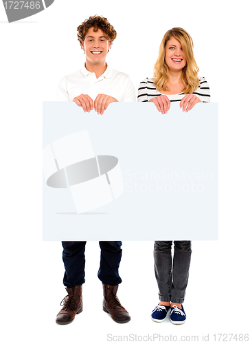 Image of Young couple standing with white board