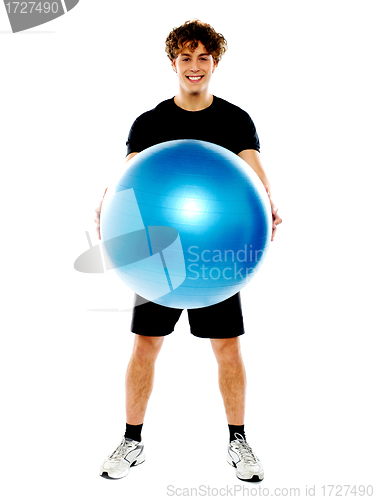 Image of Male fitness trainer holding a pilate ball