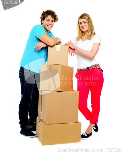 Image of Teenager couple posing beside cardboard boxes