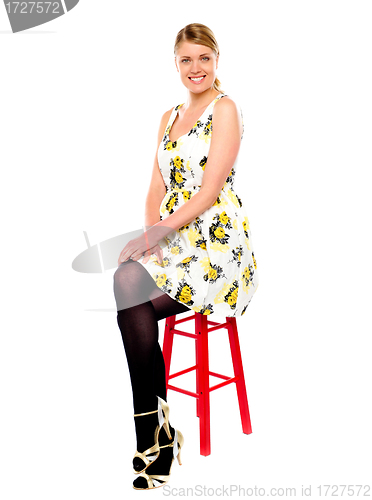 Image of Glamourous woman sitting on stool