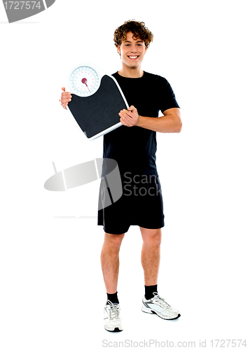Image of Handsome fit man holding weight machine