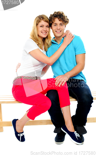 Image of Young couple hugging on bench