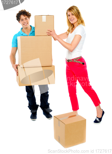 Image of Young couple holding and moving boxes