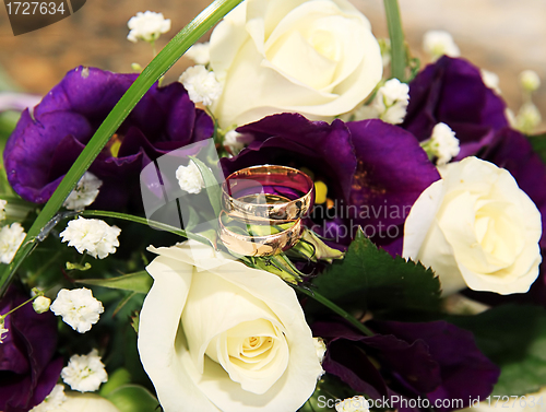 Image of wedding rings and roses arrangements