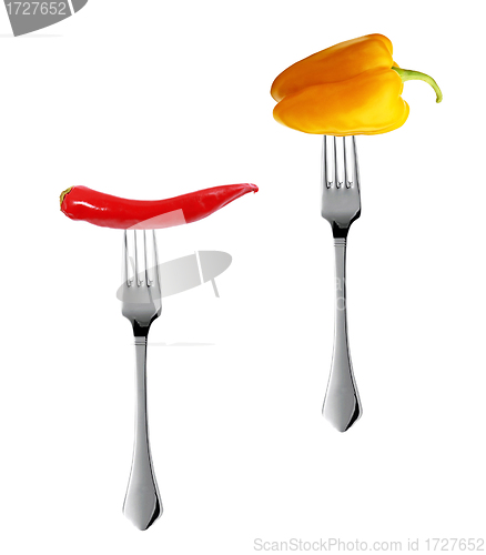 Image of Red hot chili pepper with yellow pepper pricked on forks