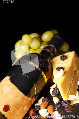 Image of red wine bottle with grape and cheese