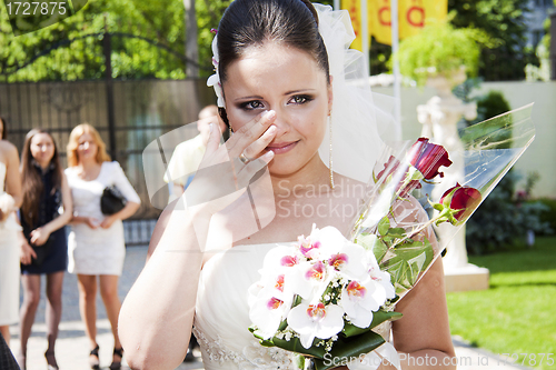 Image of Emotional bride holding floral bouquet bridal