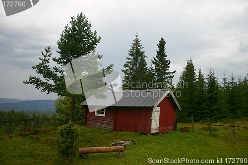 Image of Red cottage in rainy summer landscape