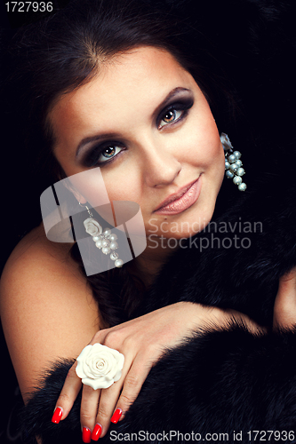 Image of brunette girl posing in studio on dark background